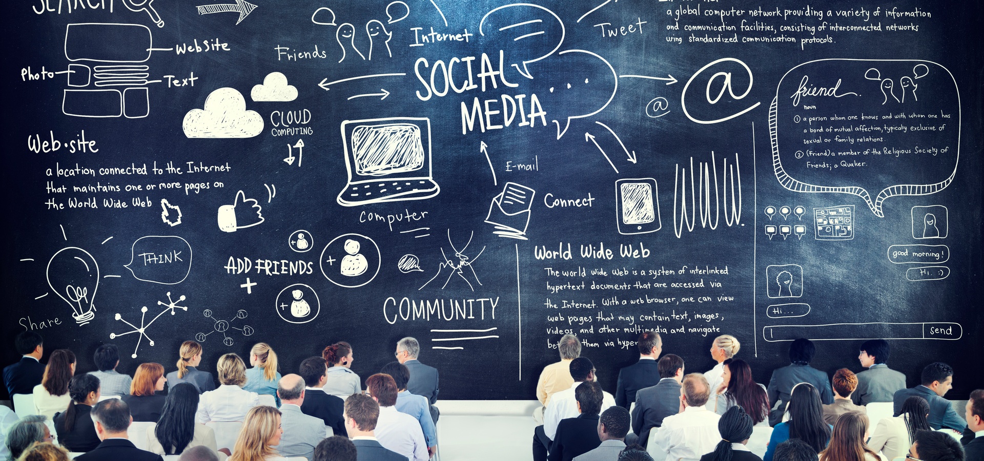 Large group of people looking at chalkboard displaying Social Media information