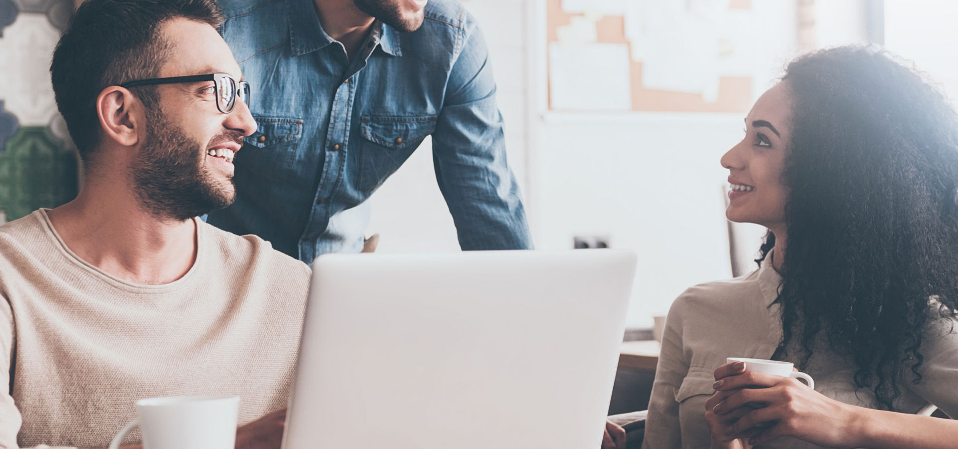 People looking at each other with smile while sitting at the office table