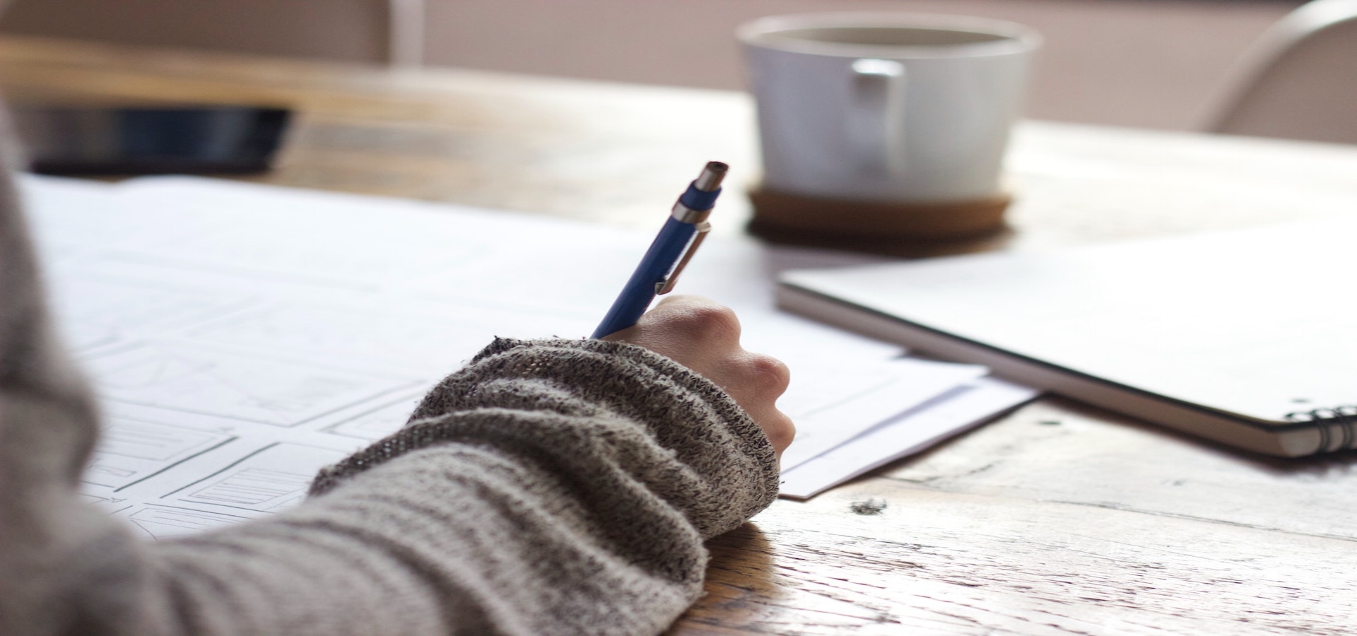 Top view of woman's hand writing on paper