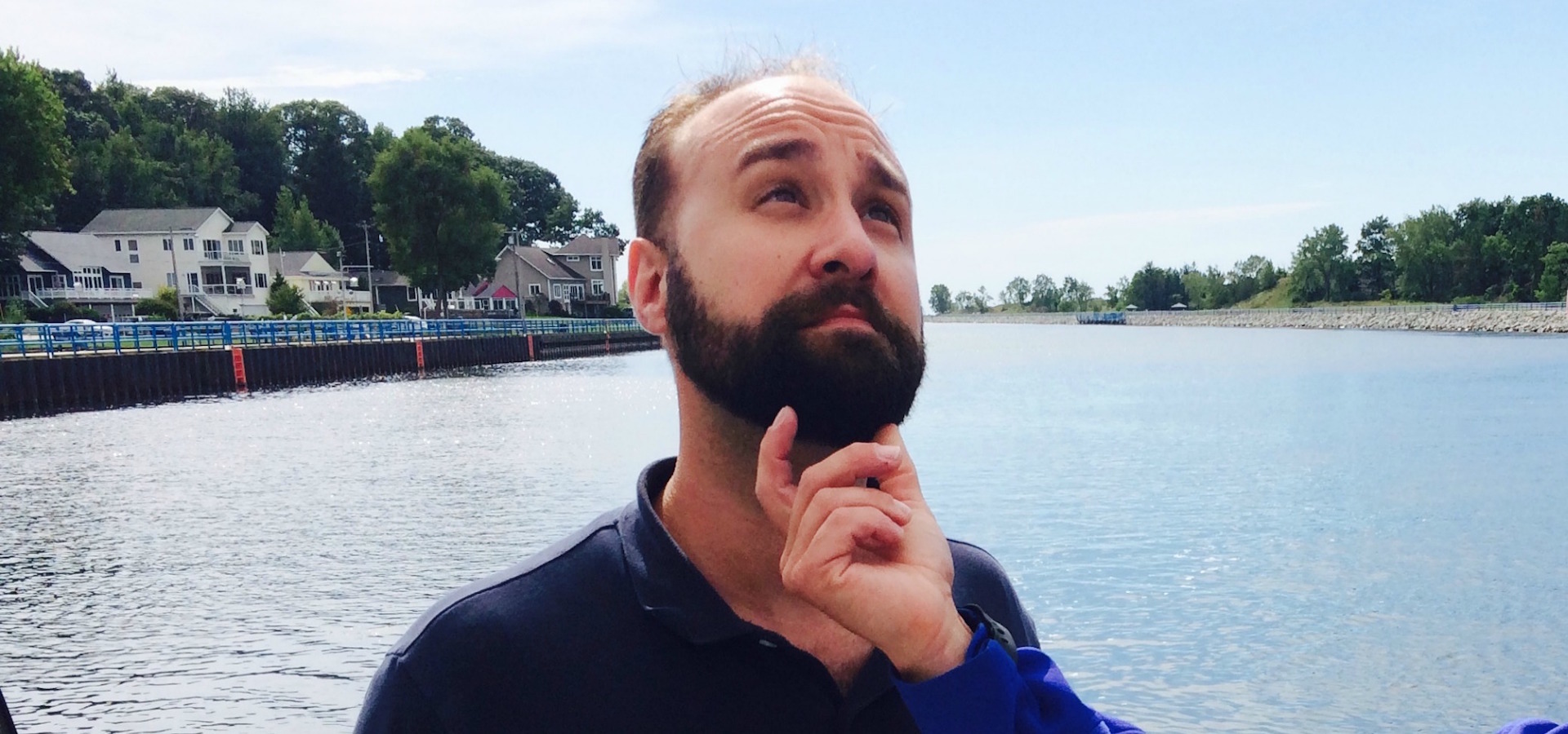 A hand is feeling Andy Maciejewski's dark beard