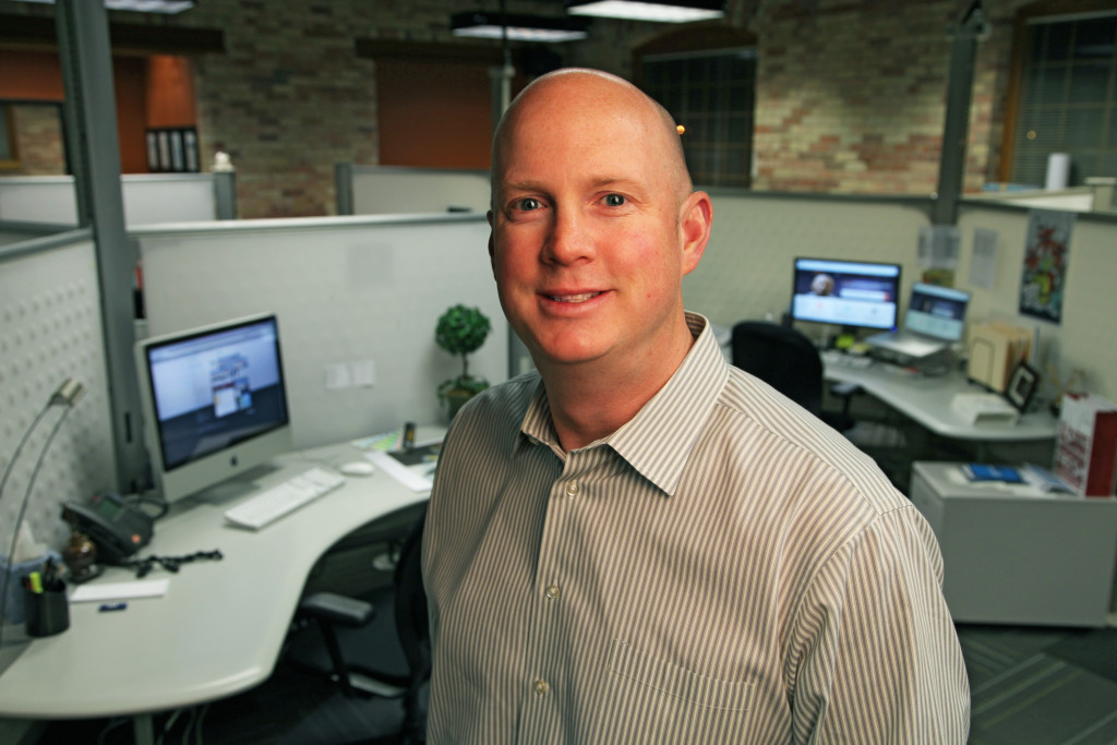 Jason Piasecki posing in front of desk in Revel office