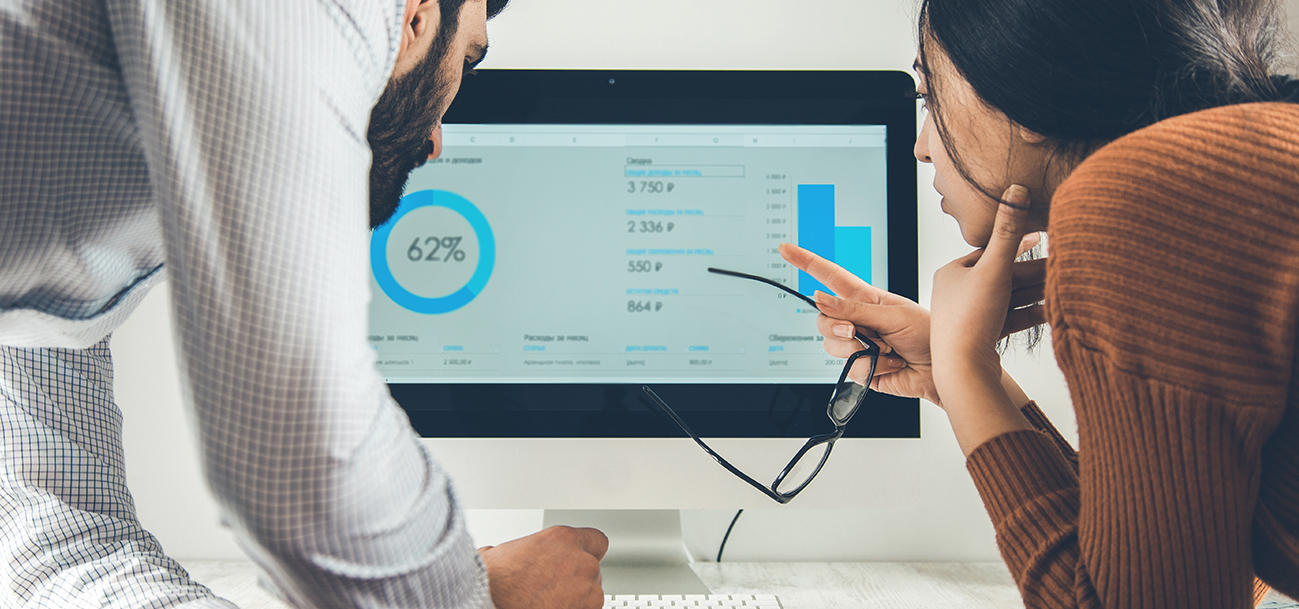 Two people looking at analytics on a computer screen