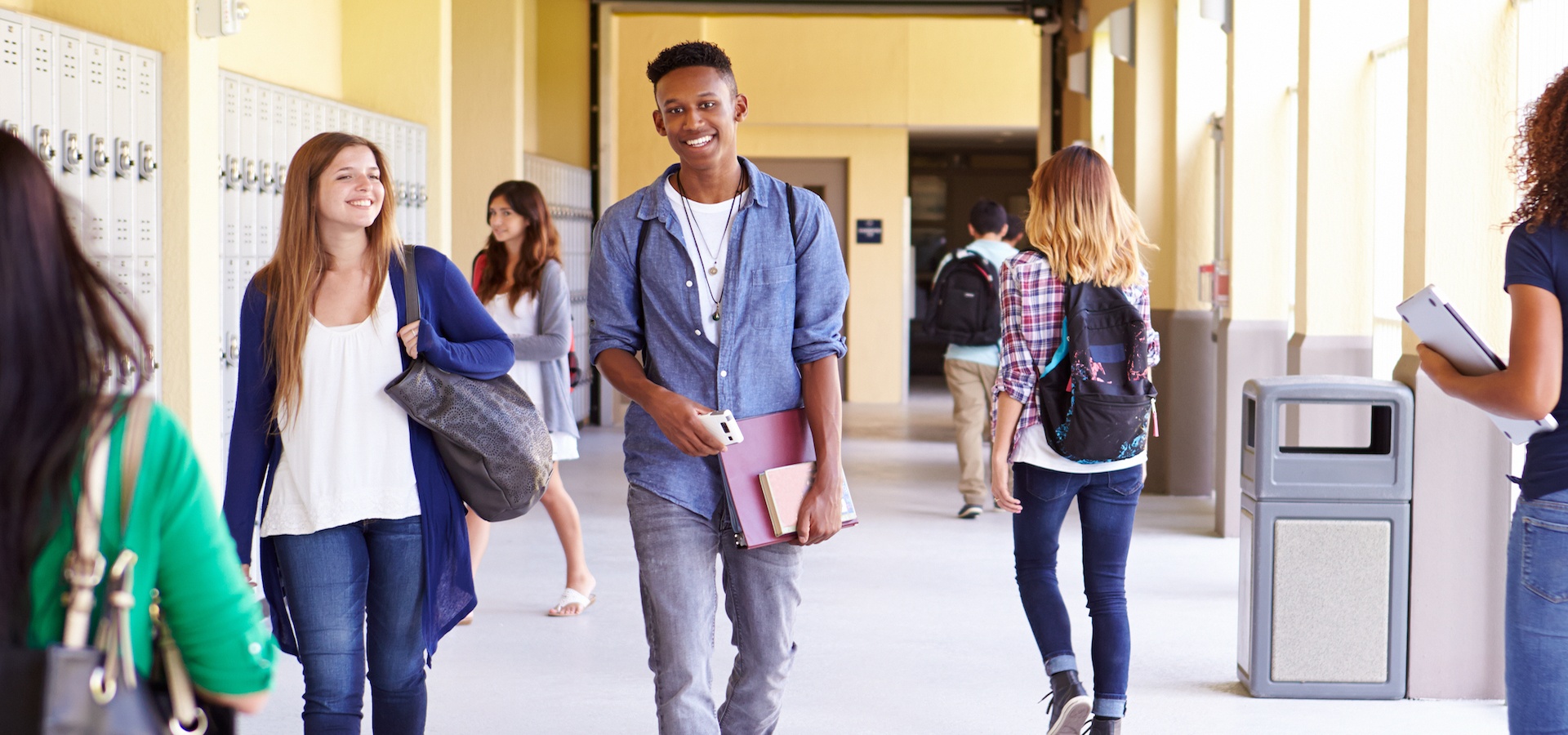 Happy teenagers walking down the hallway at school
