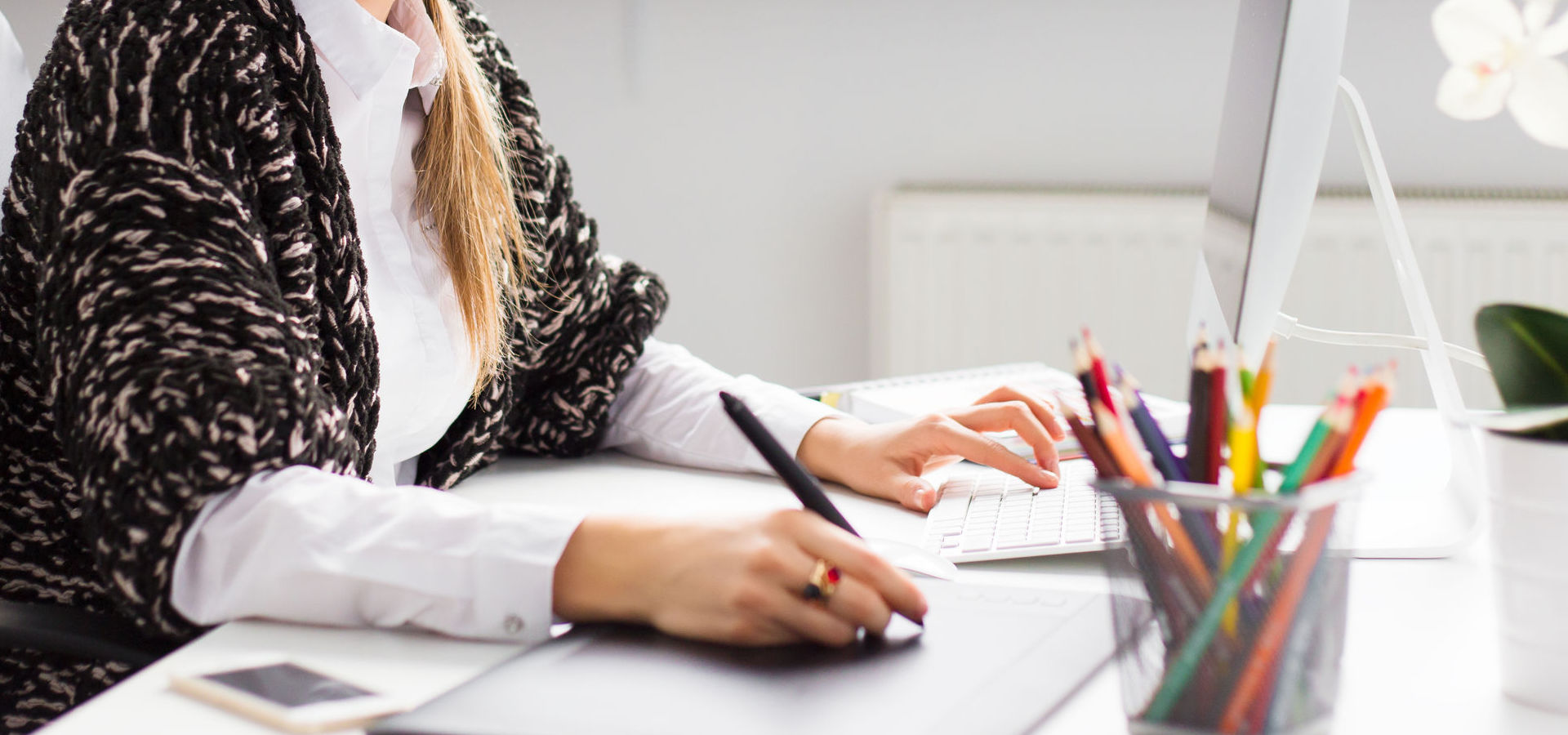 Woman writing on graphics tablet and computer
