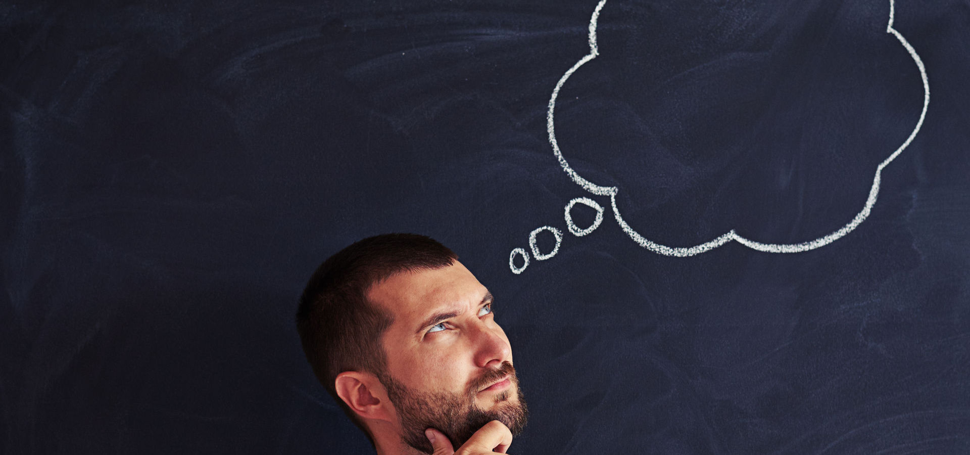 Man pondering empty thought bubble